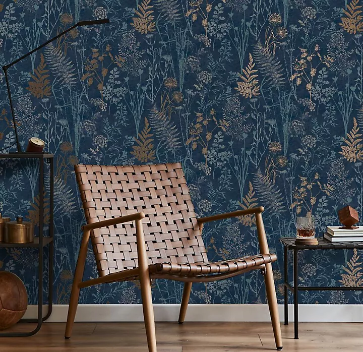 Giấy dán tường hiệu ứng bê tông công nghiệp trong phòng khách với ghế bành và ghế đôn màu xám và bàn console màu đen.