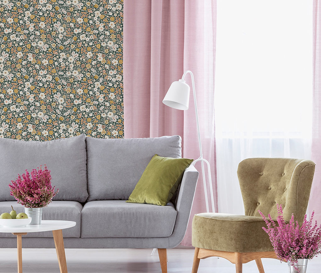 Giấy dán tường hình thoi hình học màu xanh lá cây đậm và kim loại trong phòng khách với ghế sofa và ghế bành màu xám.