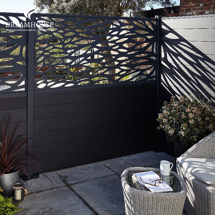Hàng rào sân vườn hiện đại màu xám đậm với các tấm cắt trang trí, tăng thêm sự riêng tư, phong cách và nét hiện đại cho không gian ngoài trời.