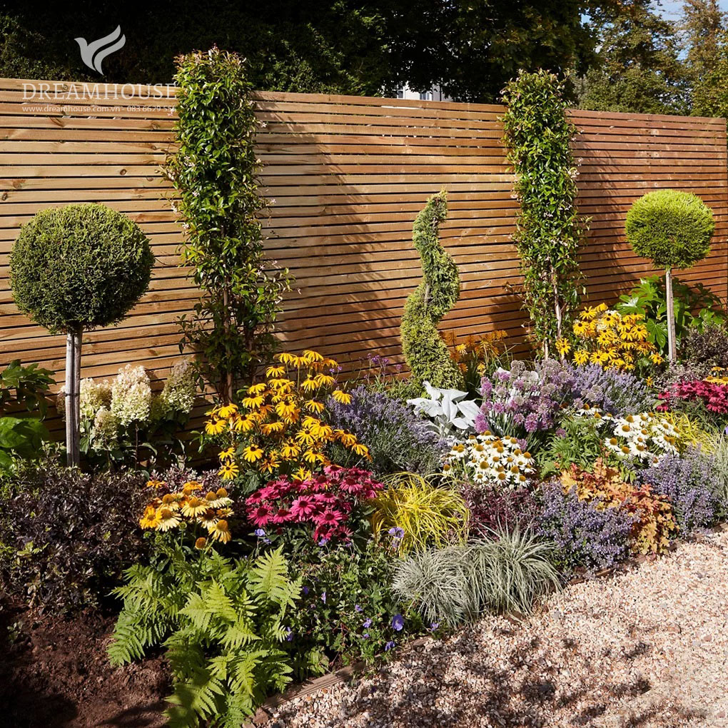 Một khu vườn rộng lớn với nhiều loại cây xanh, cây bụi và cây nhỏ đầy màu sắc.