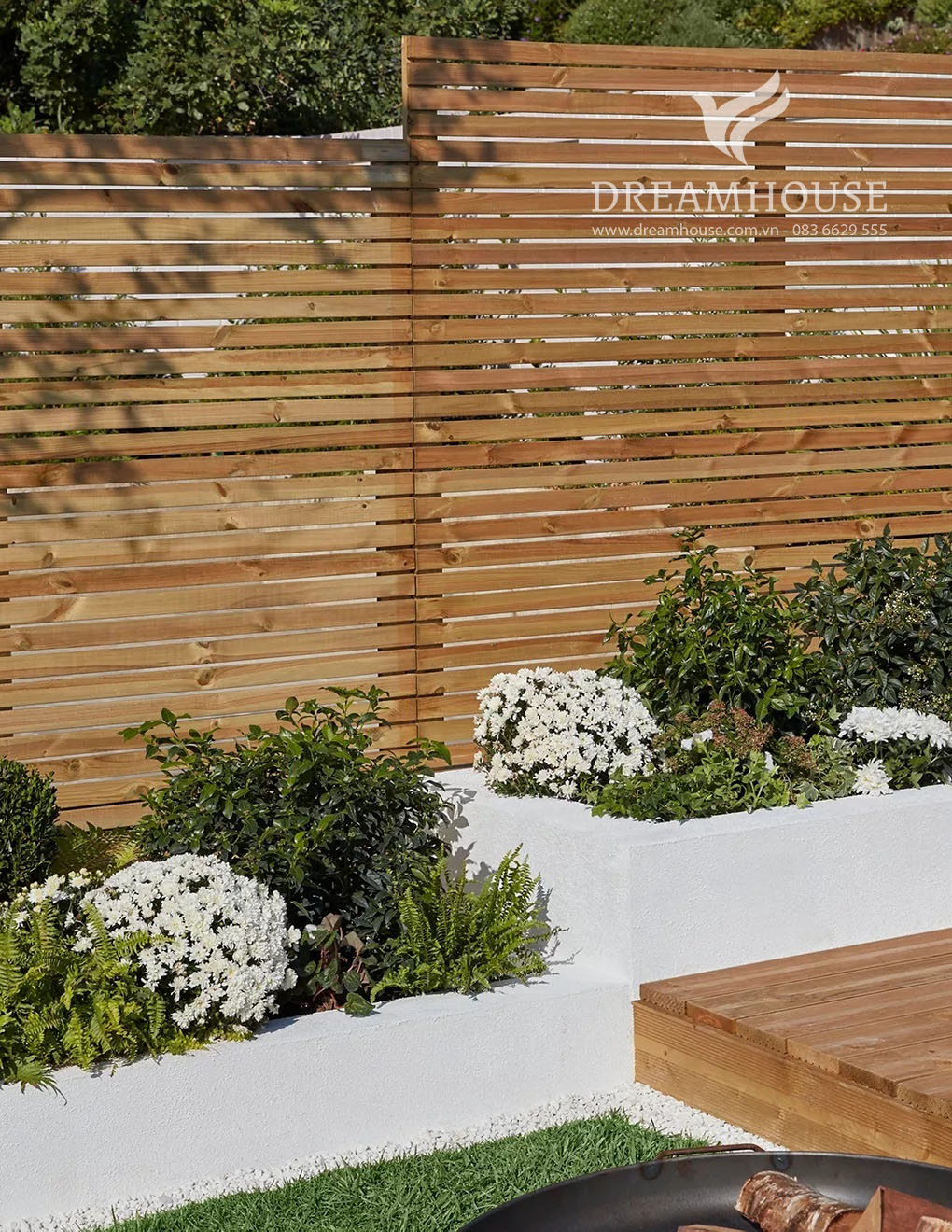 Những luống vườn cao bằng đá trắng đầy cây bụi và hoa.