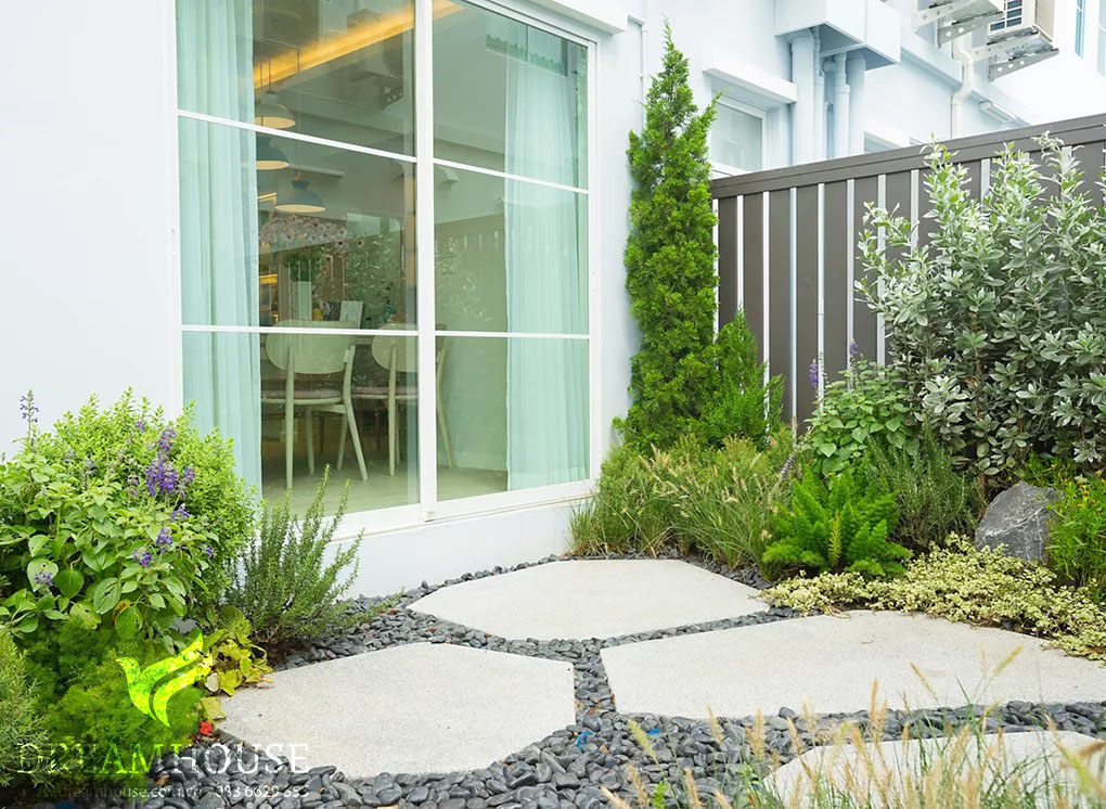 Những viên đá bước màu trắng đặt trên sỏi màu xám đậm, tạo nên lối đi thanh lịch với độ tương phản nổi bật và là điểm nhấn quyến rũ trong khu vườn.