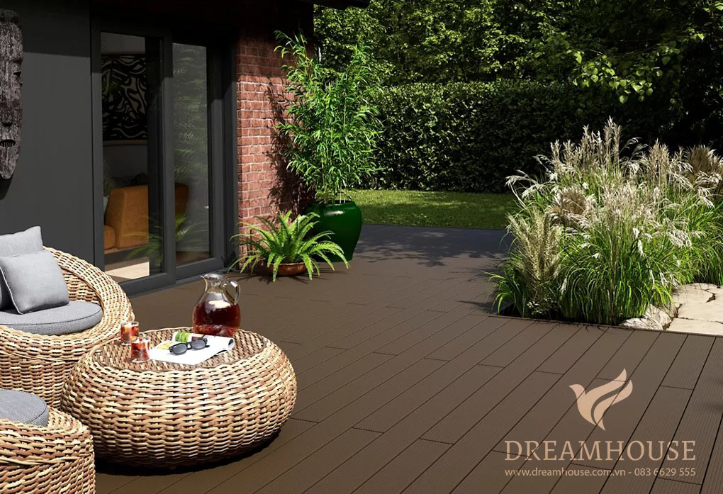 Khu vườn hiện đại với sàn gỗ màu nâu sẫm, đồ nội thất bằng mây và sự kết hợp nhiều vật liệu, mang đến không gian ngoài trời thư giãn và sang trọng.